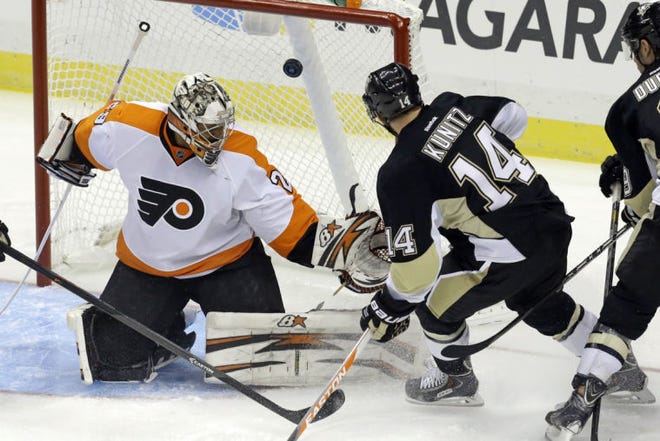 Pittsburgh's Chris Kunitz (14) puts the puck behind Flyers goalie Ray Emery in the first period Wednesday. The goal was disallowed because the puck went in off Kunitz's skate.