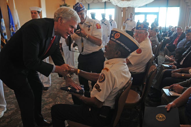 Congressman Ander Crenshaw presents a flag flown over the U.S. Capital to Retired Command Sgt. Major William Smith during a special recognition ceremony hosted by the congressman at Naval Station Mayport on Nov. 8. Smith is a member of the Military Order of the Purple Heart and was inducted into the Ranger Hall of Fame for gallantry in action, extraordinary dedication to duty and distinguished Ranger leadership over a long Army career.