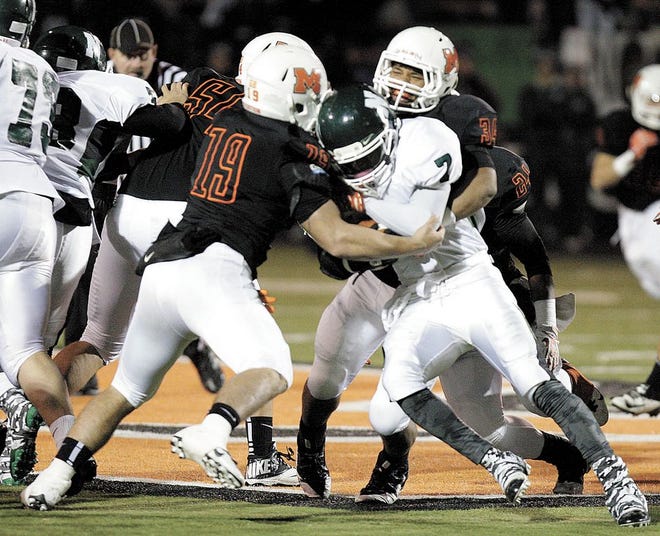 Massillon’s JD Crabtree (left) and Devon Ingram work to bring down Nordonia’s Sterling Brabson during last week’s opening OHSAA Division II playoff game at Paul Brown Tiger Stadium.