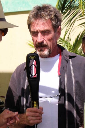 In this Thursday Nov. 8, 2012 photo software company founder John McAfee speaks at the official presentation of equipment ceremony that took place at the San Pedro Police Station in Ambergris Caye, Belize. McAfee, 67, has been identified as a "person of interest" in the killing of his neighbor, 52-year-old Gregory Viant Faull, whose body was found on Sunday. Police are urging McAffe to come in for questioning. (AP Photo/Ambergris Today Online-Sofia Munoz)