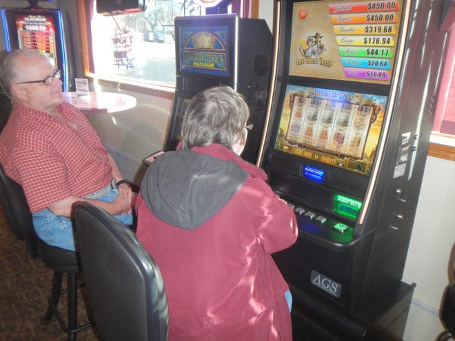 Gary Matthews watches his wife Linda try her luck at a video poker machine on Wedensday, Nov. 13, 2013, at Jumpin Joes Sports Bark & Grill in Freeport.