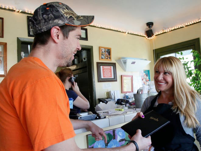 Betty Fraser, the owner of Los Angeles restaurant Grub, right, greets customer Carter Haley. Fraser's restaurant Grub, has joined the services of an online food ordering company GrubHub, which takes about 15 percent of each order.
