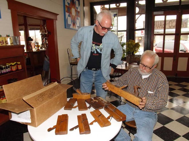 From left, Steve "Bud" Hund, owner of Mill Creek Antiques, and Guy Michael, manager and sales associate at the business, talk about a collection of handmade wooden planes that may have been used during the construction of the Statehouse. Hund purchased the planes, thought to have been made in the 1840s, from a Junction City woman. The steel blades on the planes may have been hand-forged.
