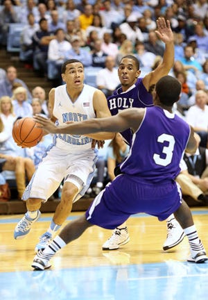 North Carolina's Marcus Paige, left, tries to drive around Holy Cross' Cullen Hamilton, center, and Justin Burrell during the first half of Friday night's game.
