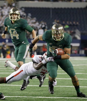 Baylor running back Devin Chafin, front, breaks a tackle against Texas Tech linebacker Will Smith (7) as he rushes for a touchdown after the handoff from quarterback Bryce Petty (14) during the first half of an NCAA college football game in Arlington, Texas, Saturday, Nov. 16, 2013. (AP Photo/LM Otero)