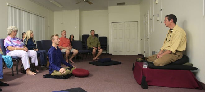 Michael Kane, far right and below, leads a meditation class Tuesday evening at the Unitarian Church in Ormond Beach. Kane uses the Metta method, which teaches love and compassion for one's self and then sending the same out to the world. Mindfulness can help take the edge off the holidays when many fret about gift-giving and the debts incurred.