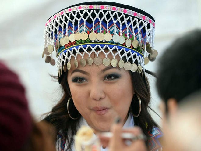 Panhina Kue, 20, of Spartanburg in traditional dress at a meal. Traditional costumes, dancing, music and food are part of the Hmong New Year Festival held this Saturday and Sunday at the Piedmont Interstate Fairgrounds in Spartanburg. The festival celebrates the culture of the Hmong, who originate from mountainous areas in several Asian countries, including Burma, China, Laos, Thailand and Vietnam.