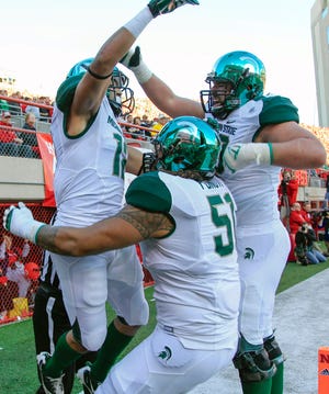 Michigan State tackle Dan France, right, and tackle Fou Fonoti (51) celebrate with R.J. Shelton, left, after Shelton scored a touchdown against Nebraska in the first half in Lincoln, Neb. on Saturday. (AP Photo/Nati Harnik)