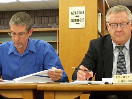 Mendon Community Schools Board of Education President Roger Cupp and Superintendent Rob Kuhlman review paperwork related to a potential millage request the district may put before voters in February.