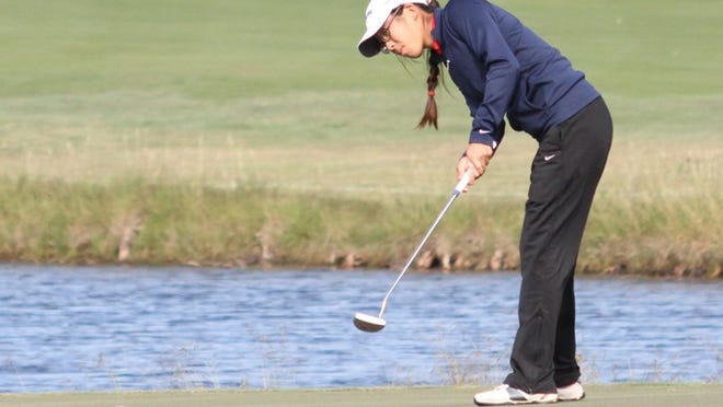 Senior Robin Tan sinks a put on the No. 15 green at Cottonwood Golf Course for par save.