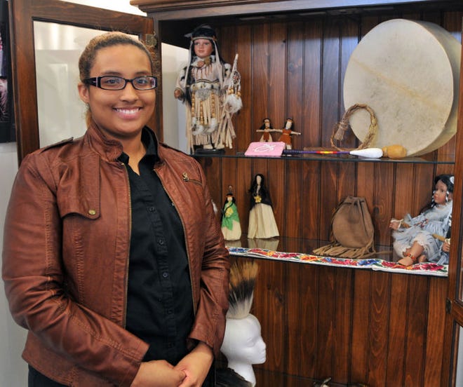 Trinity Norwood stands beside some of her family's collection of Native American art.