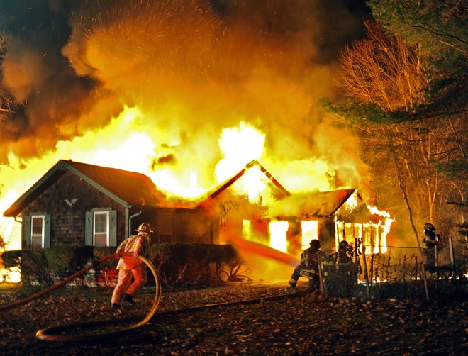 Firefighters work to extinguish a house fire at 72 Loomis Lane in Centerville Wednesday evening.