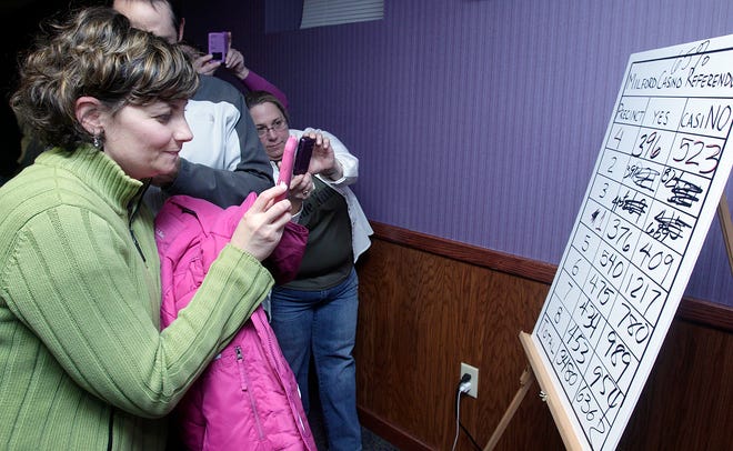 From Milford Entela Izzo, left, takes a picture of the results of Tuesday night's vote at Pinz bowling alley in Milford.