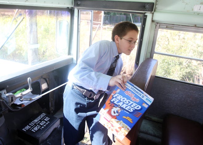 Annunciation sixth-grader Zach Beligotti carries a box of cereal as part of the school’s Fill the Bus food drive campaign. The goal is to fill the bus with non-perishable food and drive it to the Ministerial Outreach food pantry for delivery on Monday.