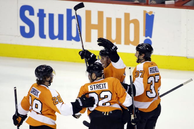 Philadelphia's Claude Giroux (from left), Mark Streit, Vincent Lecavalier and Jay Rosehill celebrate after Lecavalier's goal during the third period against the Buffalo Sabres on Thursday in Philadelphia. Philadelphia won 4-1.