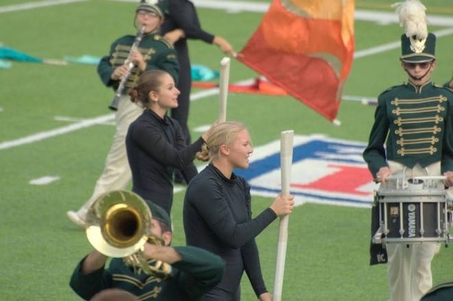Emma (front) shows off her fake-rifle-handling skills during a marching band performance.