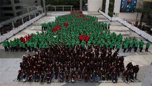 Dressed in red, green and black hoodies, 852 Thai students gather together to break the Guinness World Record for forming the largest human Christmas tree in Bangkok, Thailand Friday, Nov. 22, 2013. .
