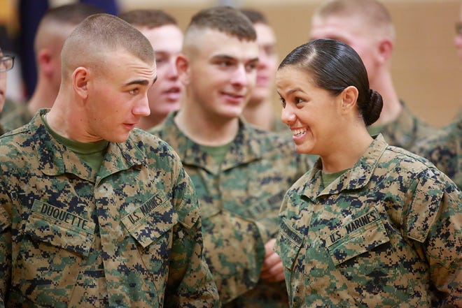 Pfc. Cristina Fuentes Montenegro, 25, right, shares a moment with a fellow Marine during a graduation ceremony aboard Camp Geiger Thursday morning. Montenegro is from Coral Springs, Fla.