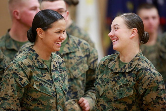Pfc. Cristina Fuentes Montenegro, 25, shares a moment with Pfc. Julia Carroll, 18, during graduation ceremony held on Camp Geiger, Jacksonville, Thursday morning. Pfc. Fuentes Montenegro is from Coral Springs, Fla., and Pfc. Carroll is from Idaho Falls, Idaho.