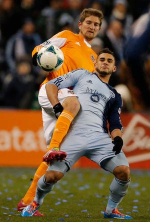 Sporting KC's Dom Dwyer, front, and Houston's Bobby Boswell get tangled while playing the ball during the first half of Saturday's MLS playoff game at Kansas City, Kan.