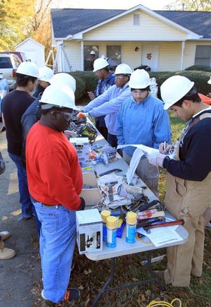 A group of Ashbrook High School carpentry students spent most of the day Wednesday working on the home of Curtis England on Welch Avenue in Gastonia. Here, the team checks equipment as they prepare to begin.