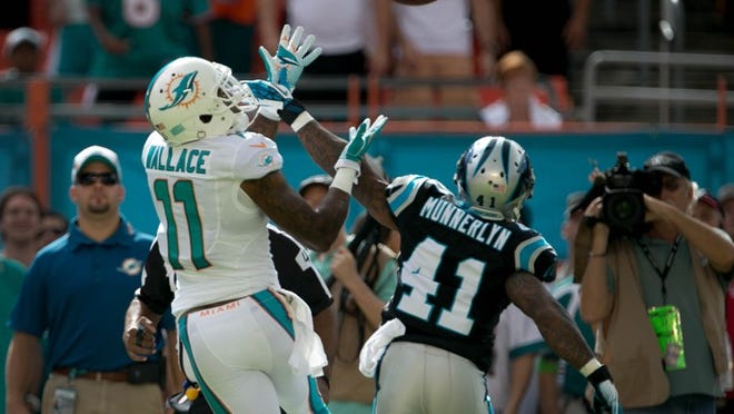 Miami Dolphins wide receiver Mike Wallace (11) catches a touchdown pass over Carolina Panthers cornerback Captain Munnerlyn (41) in the first quarter at Sun Life Stadium in Miami Gardens, Florida on November 24, 2013. (Allen Eyestone/The Palm Beach Post)
