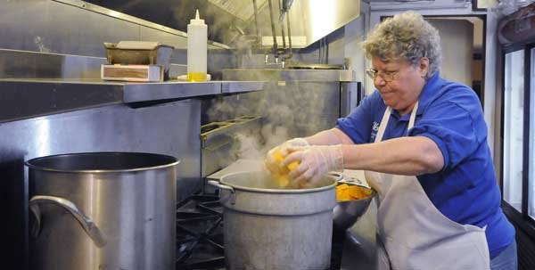 EASTHAM - 11/25/13 - Orleans-Eastham Elks Lodge secretary Kathy Gill of Eastham loads butternut squash into a pot to cook. Some 100 pounds of butternut squash will be used for a Thanksgiving Day meal for about 400 guests.