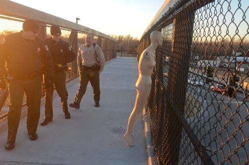 Hutchinson police officers arrive to remove a mannequin from the walking bridge over K-61 and 30th Avenue Nov. 27, 2013. A call came in to the police from a person concerned that the manikin was traffic hazard.
