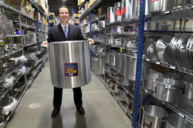 Restaurant City's Michael Friedman shows off one of the bigger pans at the open-to-the-public kitchen supply house in Providence.