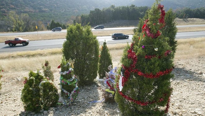Ornaments hang from trees decorated for Christmas along Highway 360 in 2012. If you decide to decorate trees this holiday season, please return to fetch your roadside decorations before they become roadside trash.