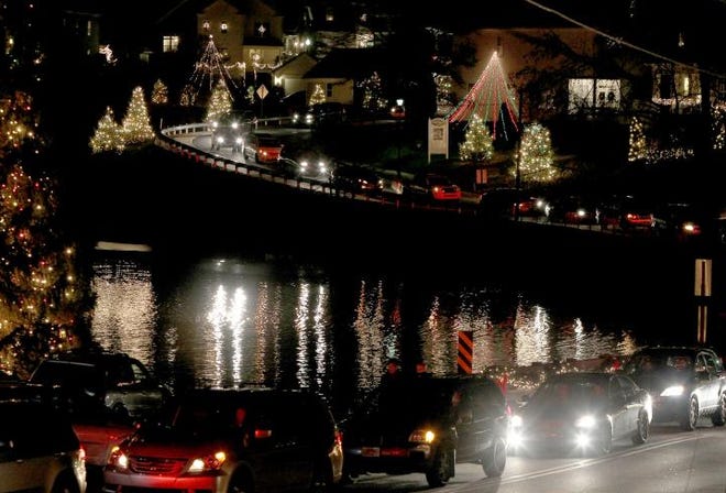 Cars wind through the streets of McAdenville during one of its recent holiday lights displays.
