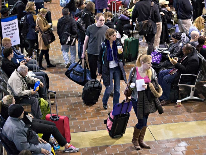 Holiday travelers navigate Amtrak's Union Station in Washington on Wednesday as a wet and blustery storm along the East Coast made driving hazardous and tangled up hundreds of flights. Bands of heavy rain, ice and snow are barreling up the East Coast as millions of Americans took to the roads, skies and rails for Thanksgiving.