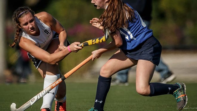 Jillian Woogemuth (left), Nook Hockey Club in Lancaster, Pa., strikes the ball as Sydney Wahl (right), Sick Field Hockey Club in Providence, R.I., battles for possession during morning gameplay at the National Hockey Festival in Wellington on Thanksgiving Day at the International Polo Club on Thursday, November 28, 2013. (Thomas Cordy/The Palm Beach Post)