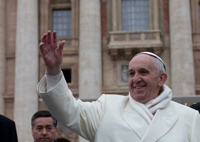 Pope Francis waves to faithful at the end of his weekly general audience in St. Peter's Square at the Vatican, Wednesday, Nov. 27, 2013. Francis has cheered the thousands of pilgrims who braved a cold snap belting Italy to attend his weekly general audience, saying they were courageous to come out. Francis himself was bundled up in a white double-breasted winter coat and scarf, but it wasn't enough. He had to use his sleeves as a muffler to keep his hands warm amid temperatures that on Wednesday dipped to freezing with the wind chill factored in. (AP Photo/Alessandra Tarantino)
