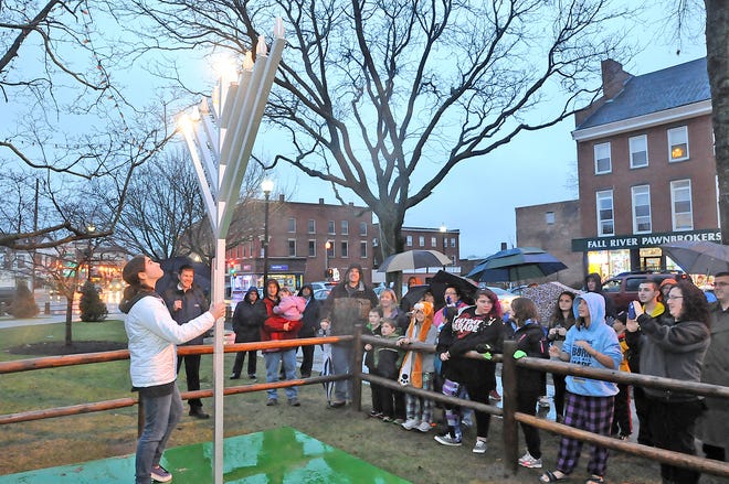Amaya Carter, 12, lights the first candle on the menorah on Taunton Green.