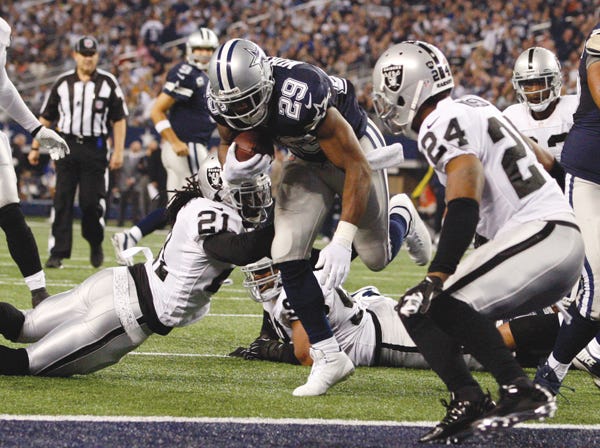 Dallas’ DeMarco Murray scores a touchdown while Oakland’s Charles Woodson (24) prepares to attempt a tackle Thursday. (Jose Yau | Waco Tribune-Herald | Associated Press)
