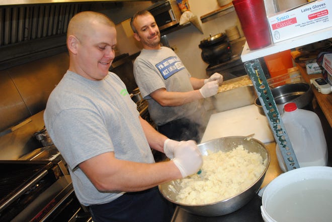 Howie Kemp mixes mashed potatoes while Ian Cramp, owner of Billy Schu's, looks on Thanksgiving morning. The two were slaving over the heat with a smile preparing 245 free meals for the Hornell community. John Anderson photo.
