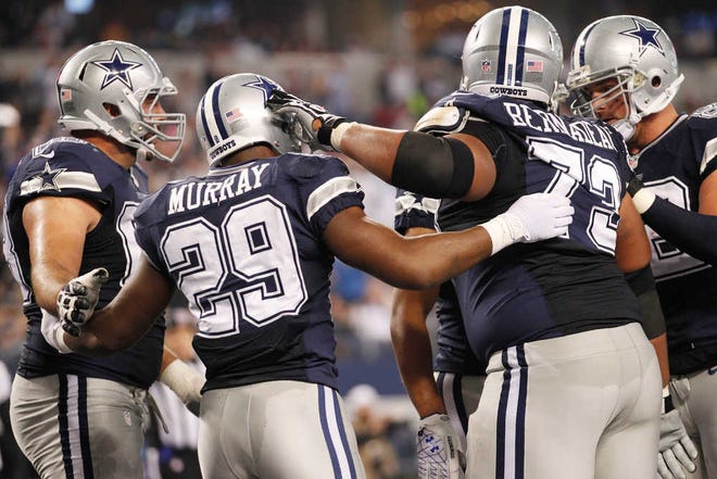 Dallas Cowboys running back DeMarco Murray (29) celebrates his touchdown against the Oakland Raiders with Doug Free (68), Jason Witten (82), and Mackenzy Bernadeau (73) during the first half of an NFL football game, Thursday, Nov. 28, 2013, in Arlington, Texas. (AP Photo/Tim Sharp)