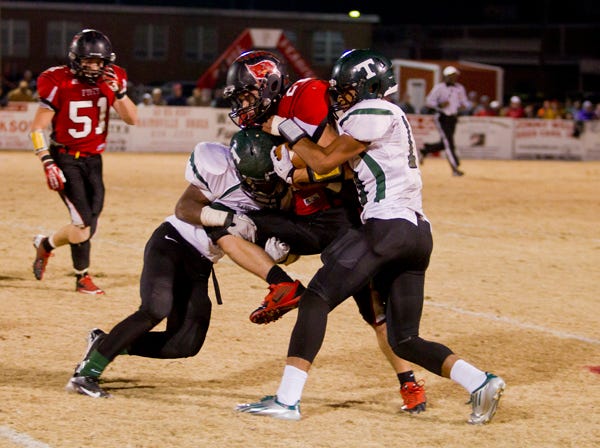 Fyffe’s Austin Stiefel gets tackled by two Tanner defenders during the teams’ Class 2A state high school football semifinal game 
Friday night in Fyffe. The No. 4 Red Devils lost 16-7 to the 
top-ranked Rattlers.