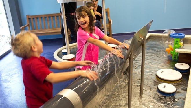 Avery Harwood, 6, and Samantha Walker, 6, play in the water-filled Currents exhibit at the Thinkery, which opens next weekend.