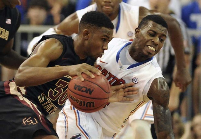Florida State guard Ian Miller (30) drives through Florida forward Casey Prather (24) during the first half of an NCAA college basketball game on Friday, Nov. 29, 2013, in Gainesville, Fla. (AP Photo/Phil Sandlin)