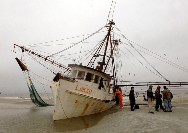 The Brunswick-based shrimpboat Little D sits on the Jekyll Island beach where it ran aground Saturday morning. A Coast Guard helicopter rescued two from the boat.