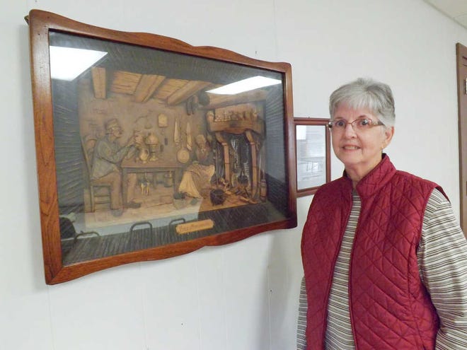 Morganville resident Nancy Johnson stands by a woodcarving residents of Feves, France, sent to the small Kansas town as an expression of their appreciation for the food, clothing and other aid sent to the European village after World War II. Johnson is helping coordinate a reception for visitors with ties to Feves in late December.