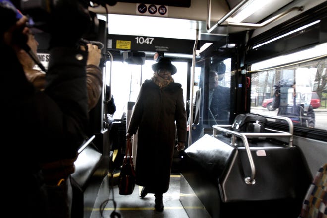 Maxine Anderson, playing Rosa Parks, walks the aisle of a RIPTA bus while participating in a reenactment Sunday.
