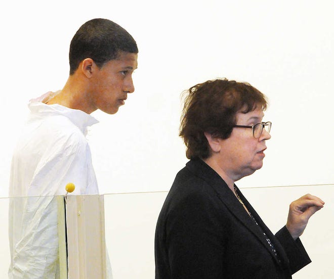 FILE - In this Wednesday, Oct. 23, 2013, file photo, Philip Chism, 14, stands during his arraignment for the death of Danvers High School teacher Colleen Ritzer, as his attorney Denise Regan speaks on his behalf in Salem District Court in Salem, Mass. News organizations, including The Associated Press, asked a Massachusetts judge Monday, Nov. 4, 2013, to lift an order barring public viewing of documents in Chism's case. (AP Photo/Boston Herald, Patrick Whittemore, File)