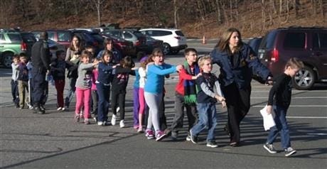 Connecticut State Police lead a line of children from the Sandy Hook Elementary School in Newtown, Conn. on Friday, Dec. 14, 2012 a shooting at the school.
