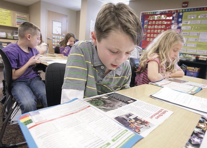 Jared Lyons a third grader in Melissa Gilson's third grade class at W.S. Stinson elementary reads aloud from Scholastic News during a social studies/reading exercise in class