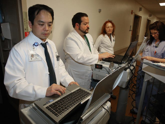 In this Dec. 10, 2012 file photo, Ocala Regional Medical Center trauma center staff, left to right, Dr. Darwin Ang, Dr. Alejandro Garcia and Dr. Bogdana Trop confer with physican extender, Jennifer Martin, right, as they do their rounds.