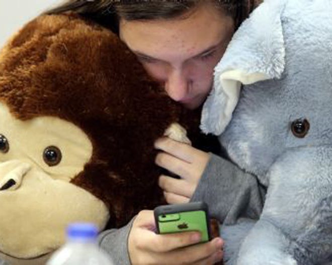 Arnold junior Paige Miller sends a text message while holding stuffed animals she purchased Wednesday at the Bay Education Foundation’s annual Christmas Store for Take Stock in Children scholars at the Nelson Building in Panama City.