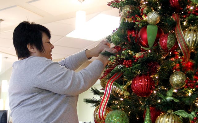 Rachel Rodemann Times Record Kay Schlaefli with Expressions Flowers decorates a Christmas tree in the Sparks Health Center lobby, Monday, Dec. 2, 2013. Expressions will adorn the whole hospital with Christmas trees, garland, ribbon and other festive decorations.